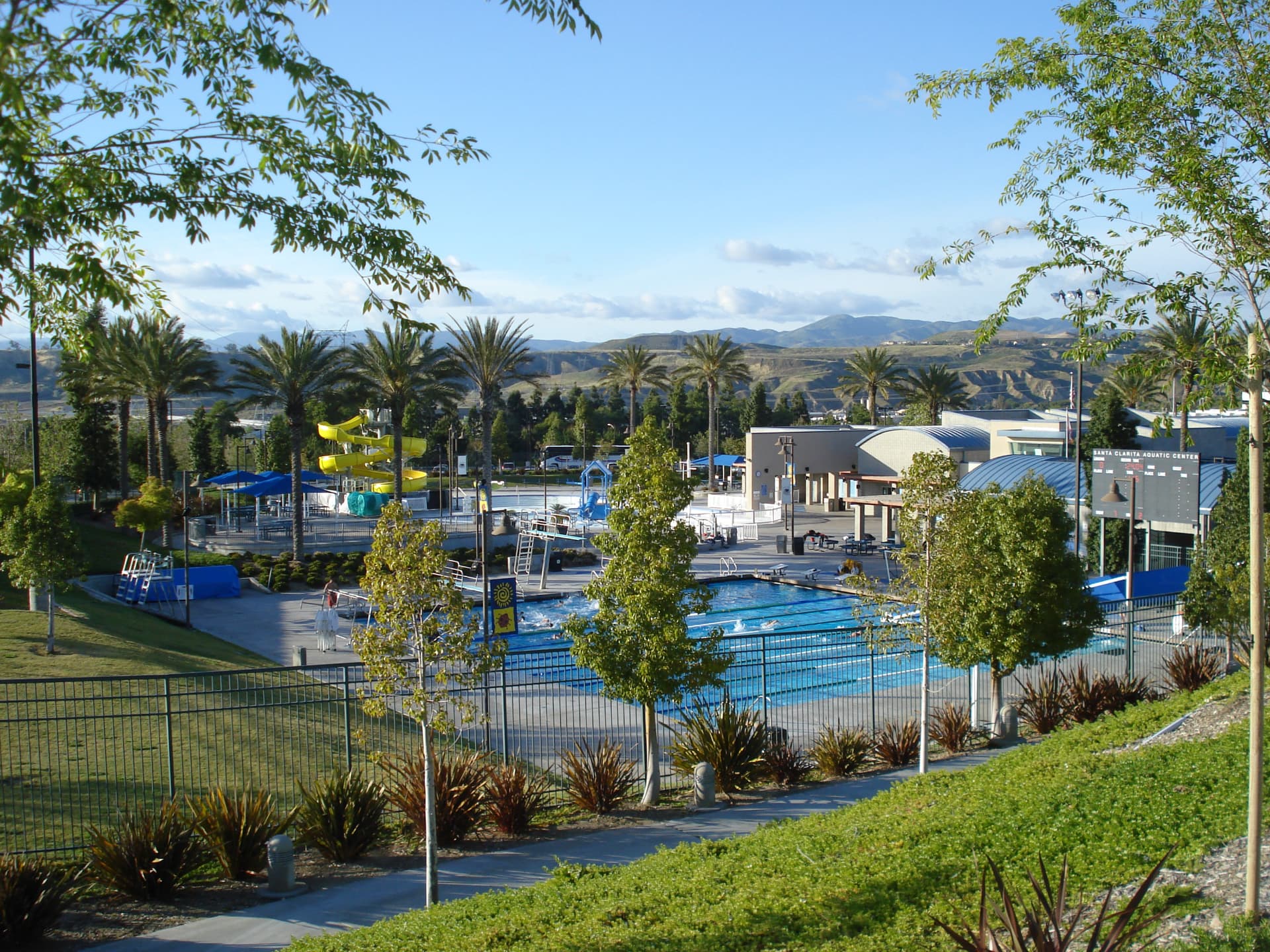 The Santa Clarita Aquatic Center and palm-lined park with the hills beyond in Canyon Country, Santa Clarita, California